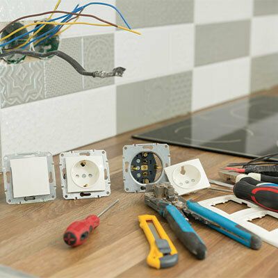 Travaux sur les raccordements électriques d’un mur carrelé